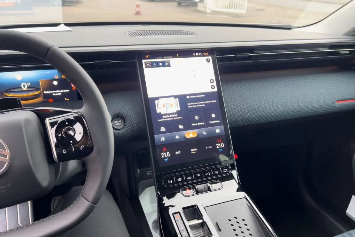 Vue intérieure centrée sur la console centrale tactile verticale et le volant cuir du Citroën C5 Aircross Hybrid blanc toit noir.