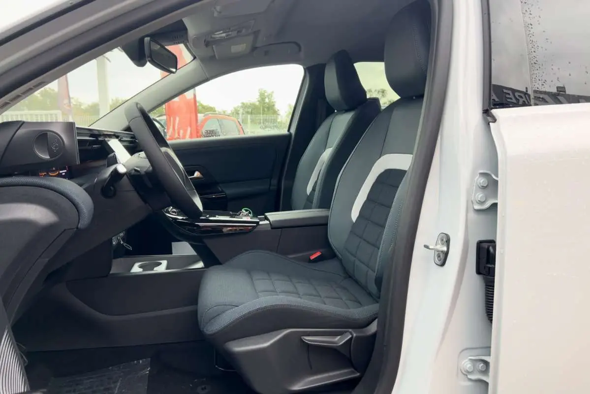 Intérieur côté conducteur du Citroën C5 Aircross blanc, sièges tissu gris avec accoudoir central et volant multifonctions.
