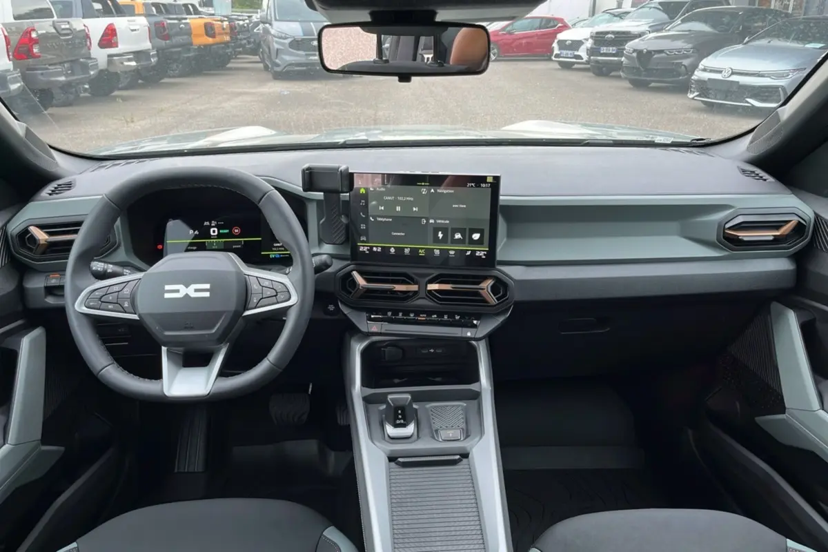 Vue intérieure du tableau de bord et volant du Dacia Bigster Hybrid 155 Extreme Plus avec écran tactile central.