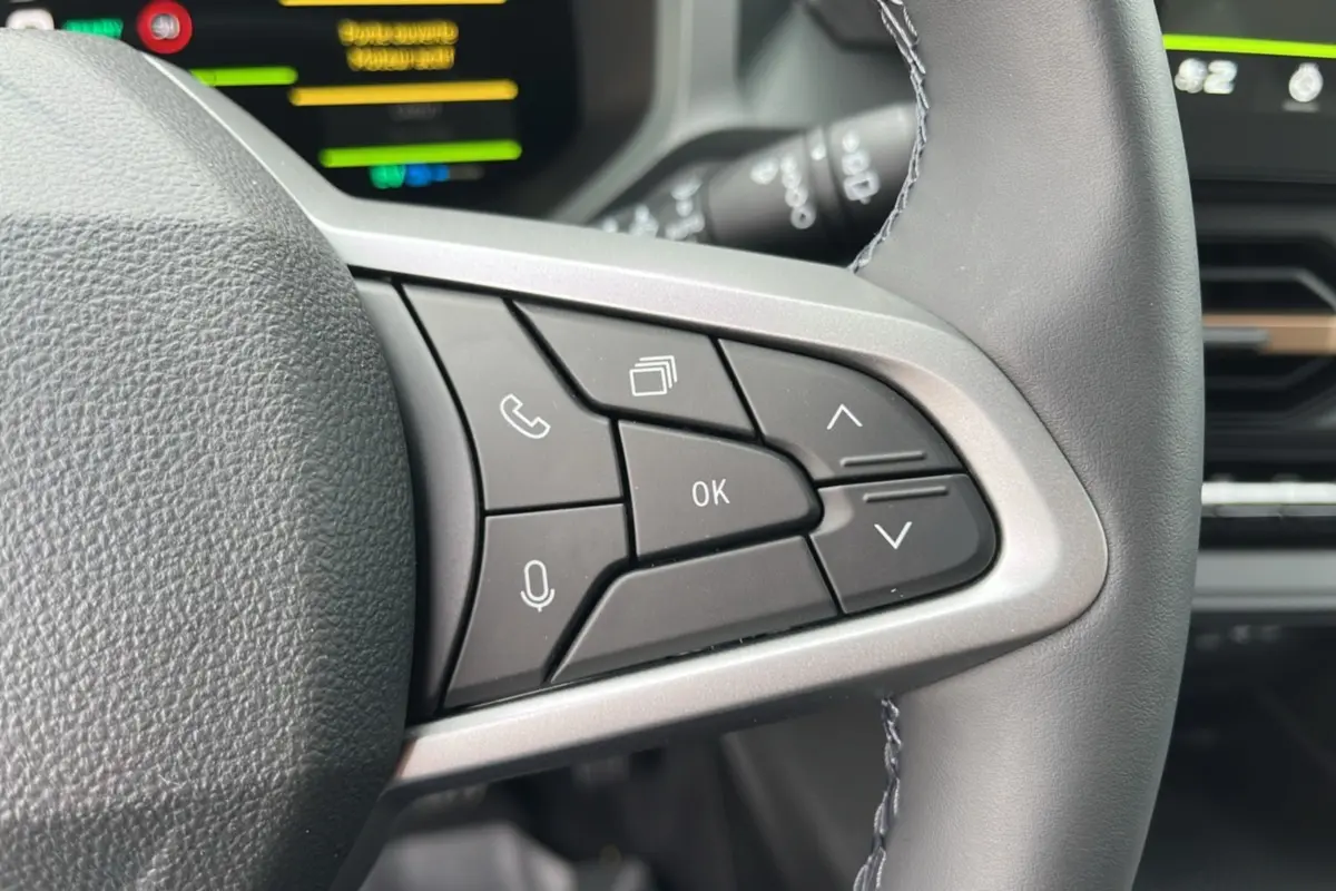 Gros plan sur les commandes au volant cuir du DACIA BIGSTER Hybrid 155 Extreme Plus, intérieur moderne et fonctionnel.