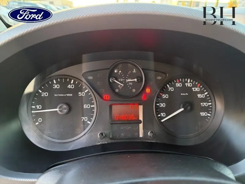 Vue rapprochée du tableau de bord avec compte-tours, compteur de vitesse et indicateurs lumineux allumés.