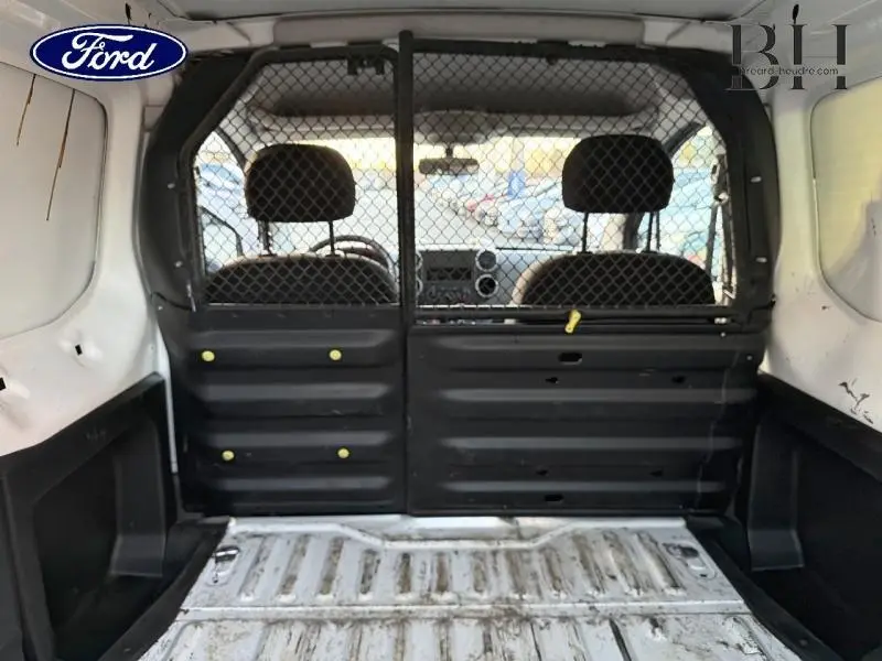 Vue intérieure arrière du Citroën Berlingo blanc 2017, montrant la cloison tubulaire et l’espace de chargement.