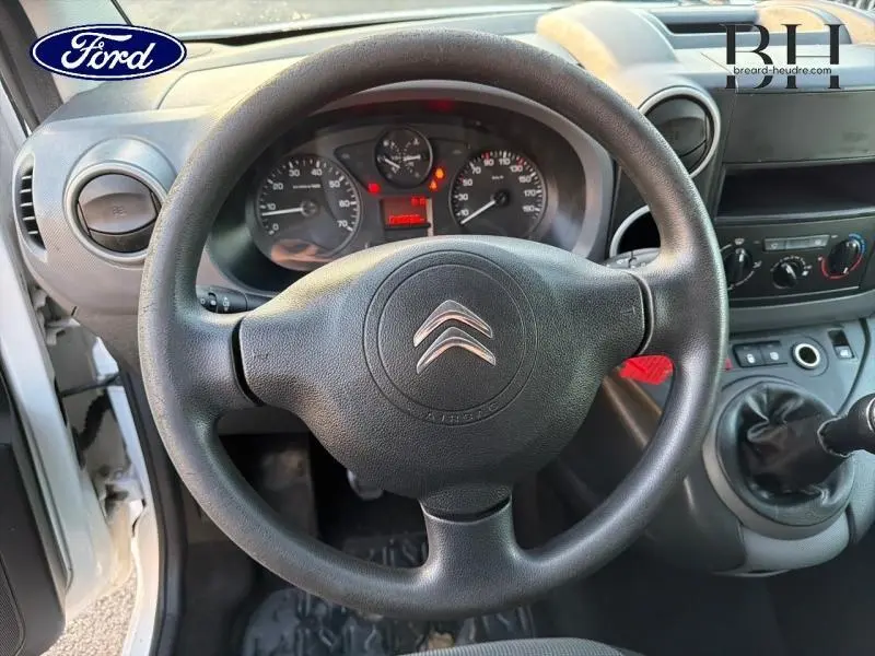 Vue rapprochée du volant noir d'un Citroën Berlingo 2017, tableau de bord et levier de vitesse manuelle visibles.