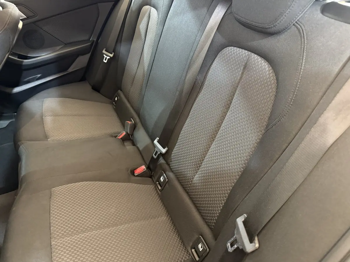 Vue rapprochée de la banquette arrière noire de la BMW Série 1 116i Business Design avec ceintures et fixations Isofix visibles.