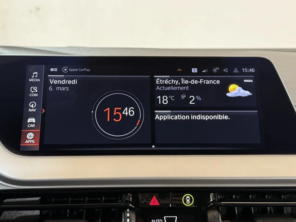 Écran tactile central de la BMW Série 1 116i Business Design affichant l'heure et la météo, intérieur beige.