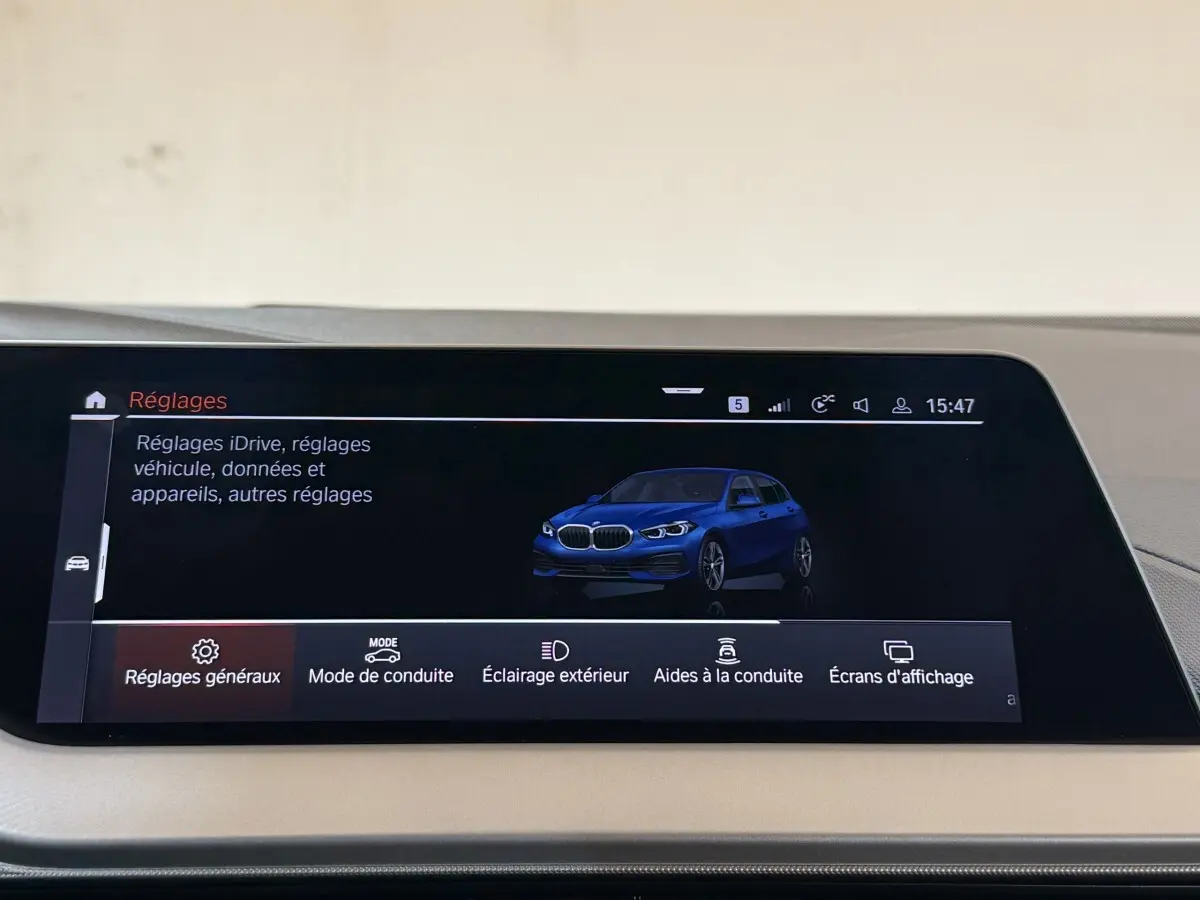 Écran tactile central affichant une BMW Série 1 bleue en 3/4 avant dans le menu Réglages du véhicule.