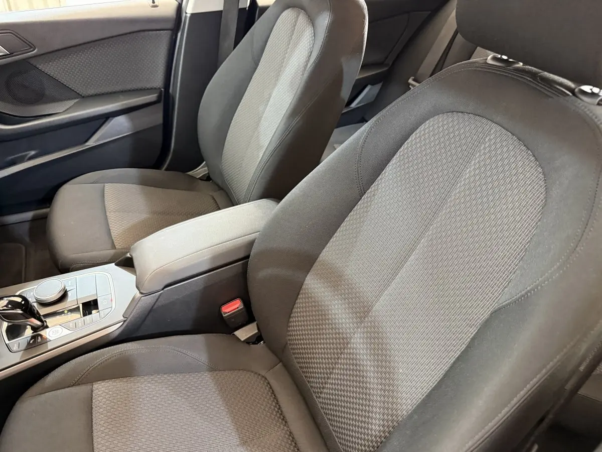 Vue rapprochée des sièges avant en tissu gris et noir de la BMW Série 1 116i Business Design 2023.