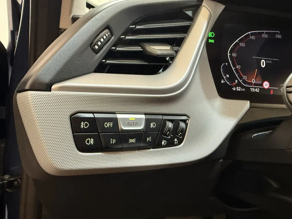 Vue rapprochée du tableau de bord côté gauche de la BMW Série 1 116i bleu, avec commandes d'éclairage et ventilation.