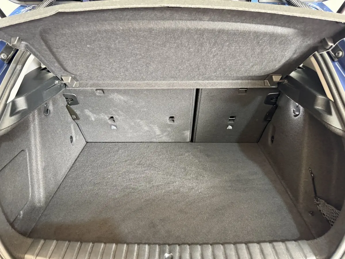 Vue intérieure du coffre spacieux et tapissé en gris foncé d'une BMW Série 1 116i Business Design 2023.
