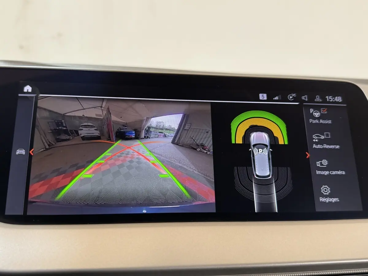 Affichage écran tactile de la BMW Série 1 bleu, vue caméra de recul avec aide au stationnement active.