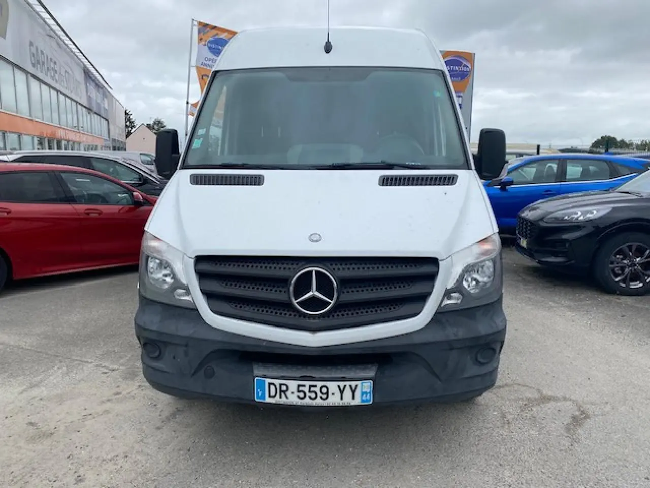 Vue frontale d'un Mercedes Sprinter fourgon blanc de 2015 avec calandre noire et pare-chocs gris.