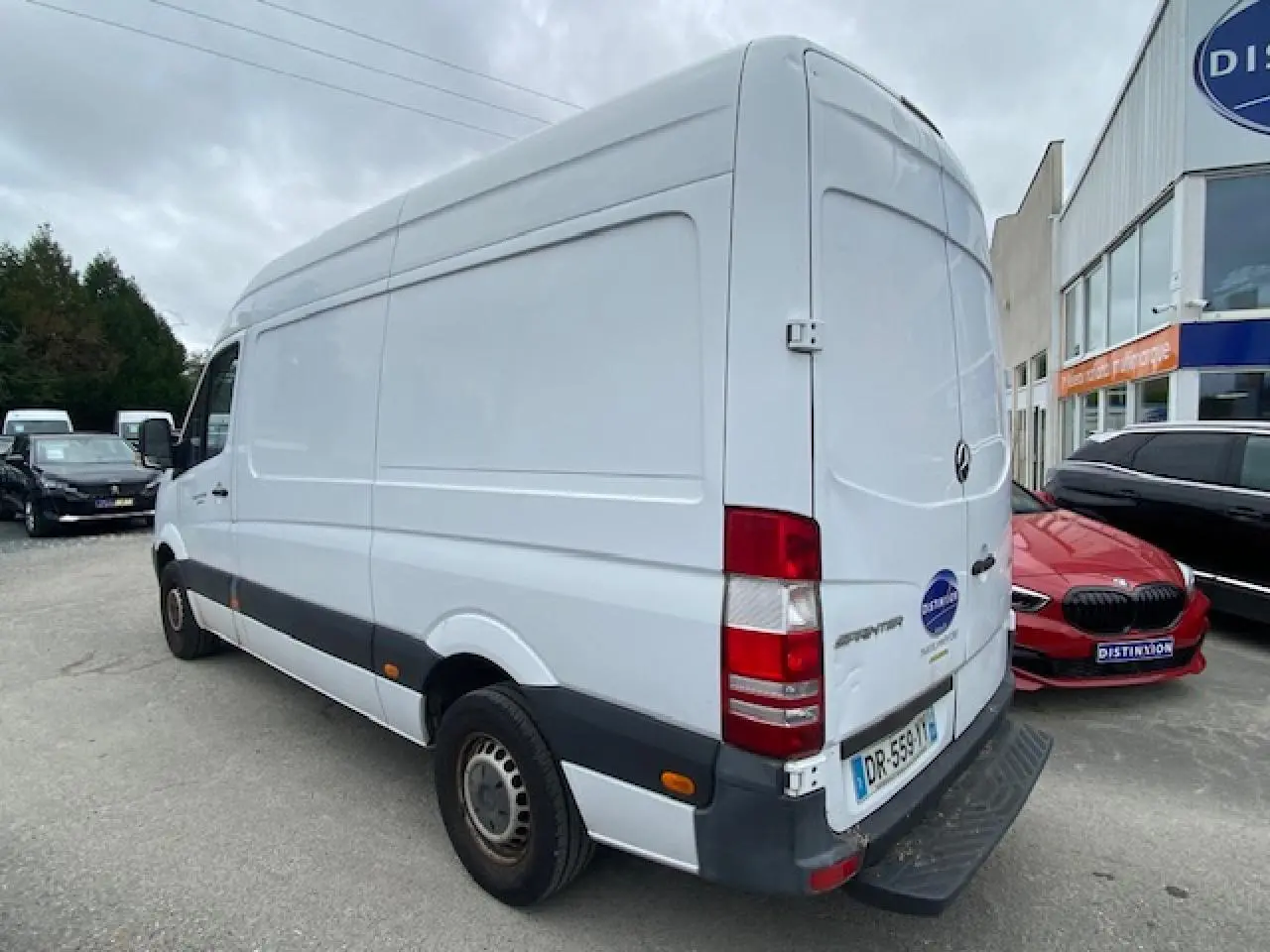 Vue 3/4 arrière droite d’un fourgon Mercedes Sprinter blanc de 2015, avec porte arrière fermée et pare-chocs noir.