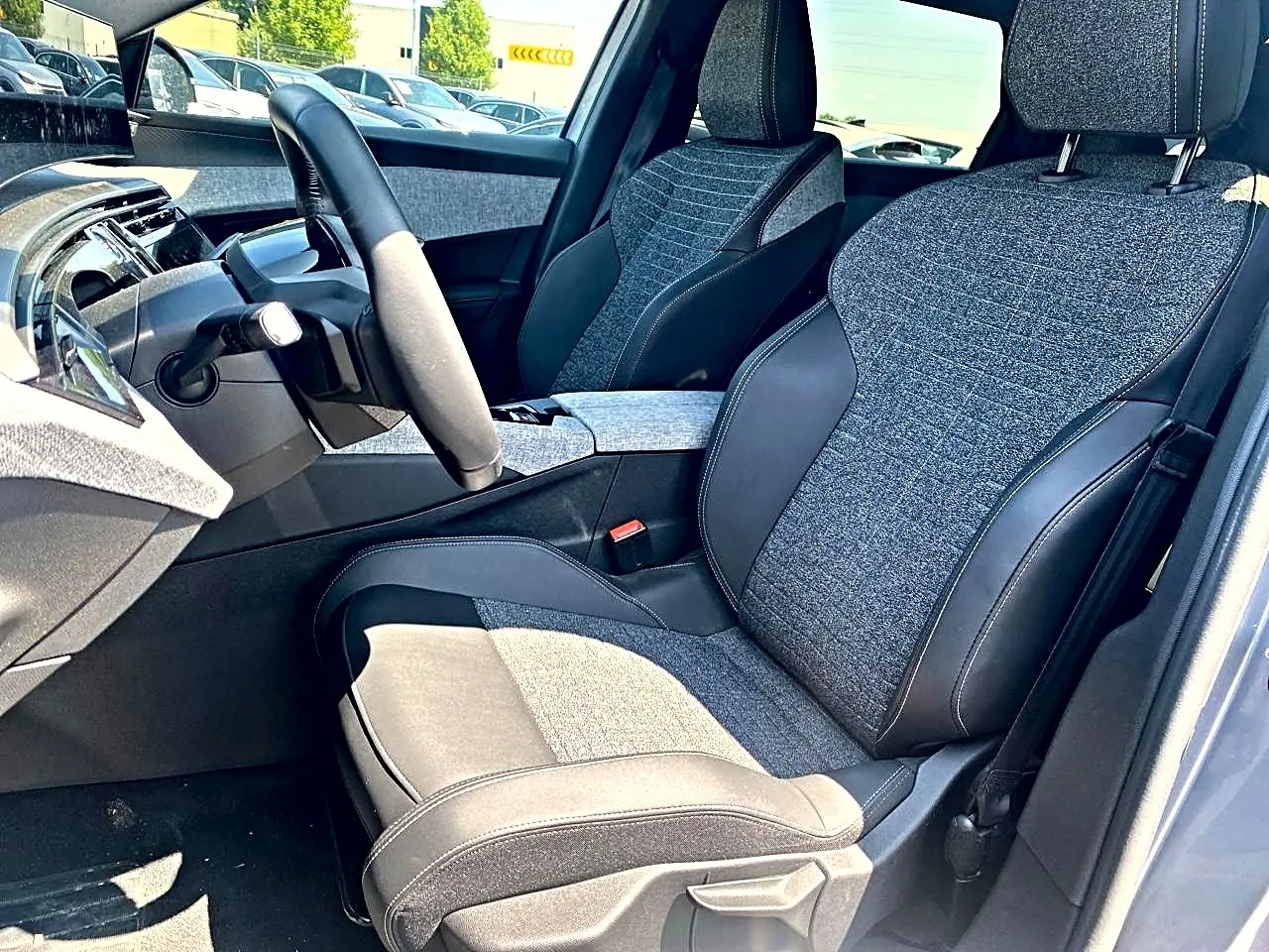 Vue intérieure côté conducteur du Peugeot 5008 Hybrid 145 allure e-dcs6 2025 avec sièges tissu gris et cuir noir.