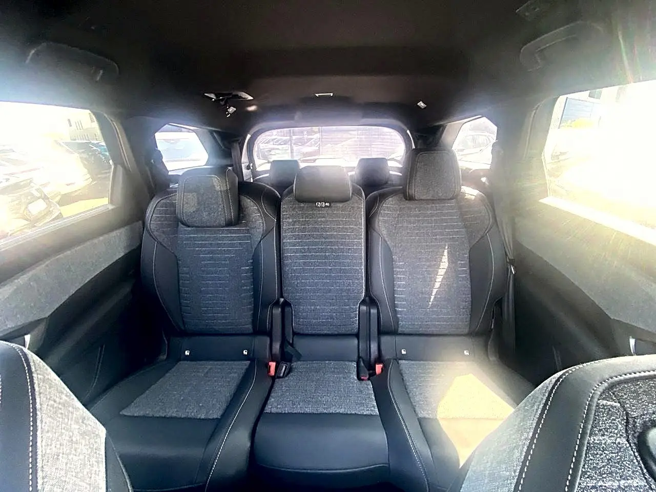 Vue intérieure arrière du Peugeot 5008 Hybrid 145 allure e-dcs6 2025, montrant les trois sièges gris avec appuis-tête.