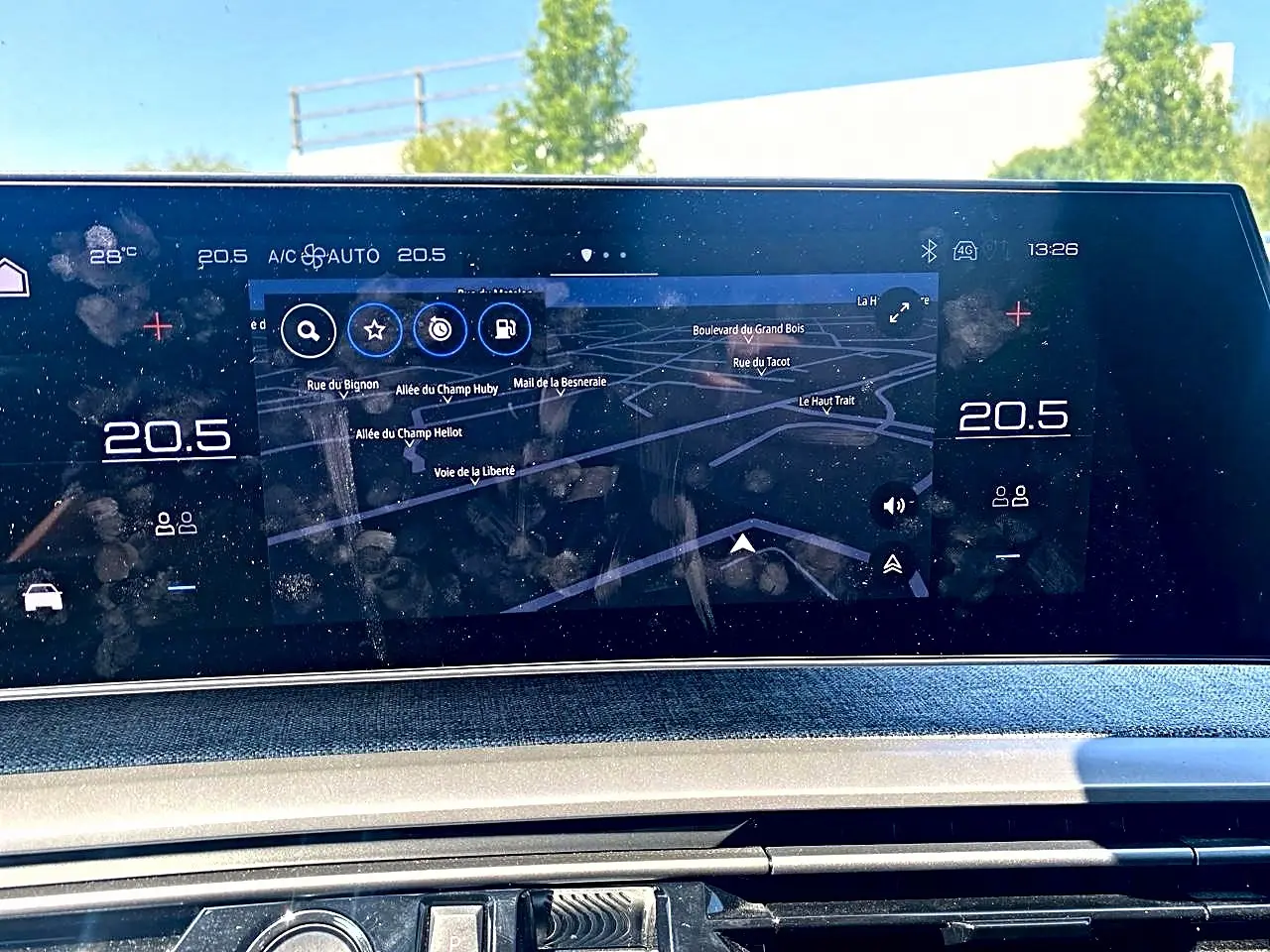 Écran tactile central affichant la navigation et la climatisation dans le Peugeot 5008 Hybrid 145 allure gris Artense.