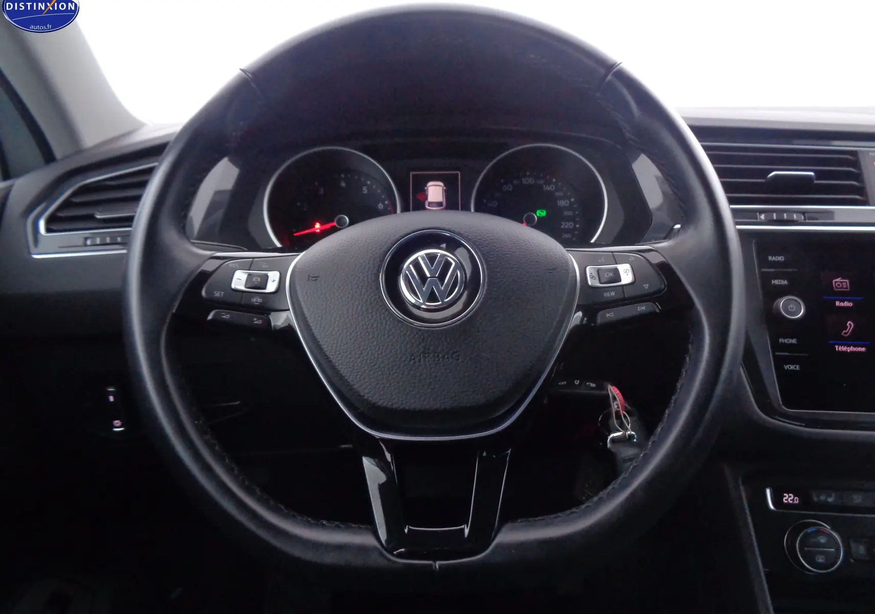 Vue rapprochée du volant en cuir noir d'un Volkswagen Tiguan 2019, avec tableau de bord et écran tactile visibles.