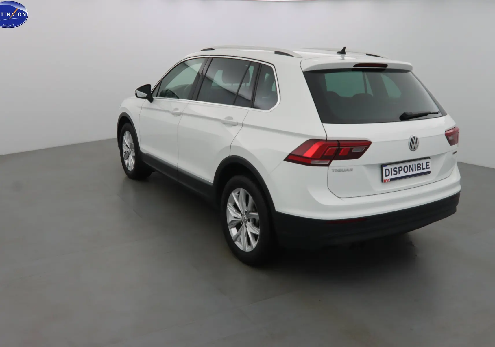 Volkswagen Tiguan blanc vue 3/4 arrière droit dans un studio, avec feux arrière LED et toit ouvrant.