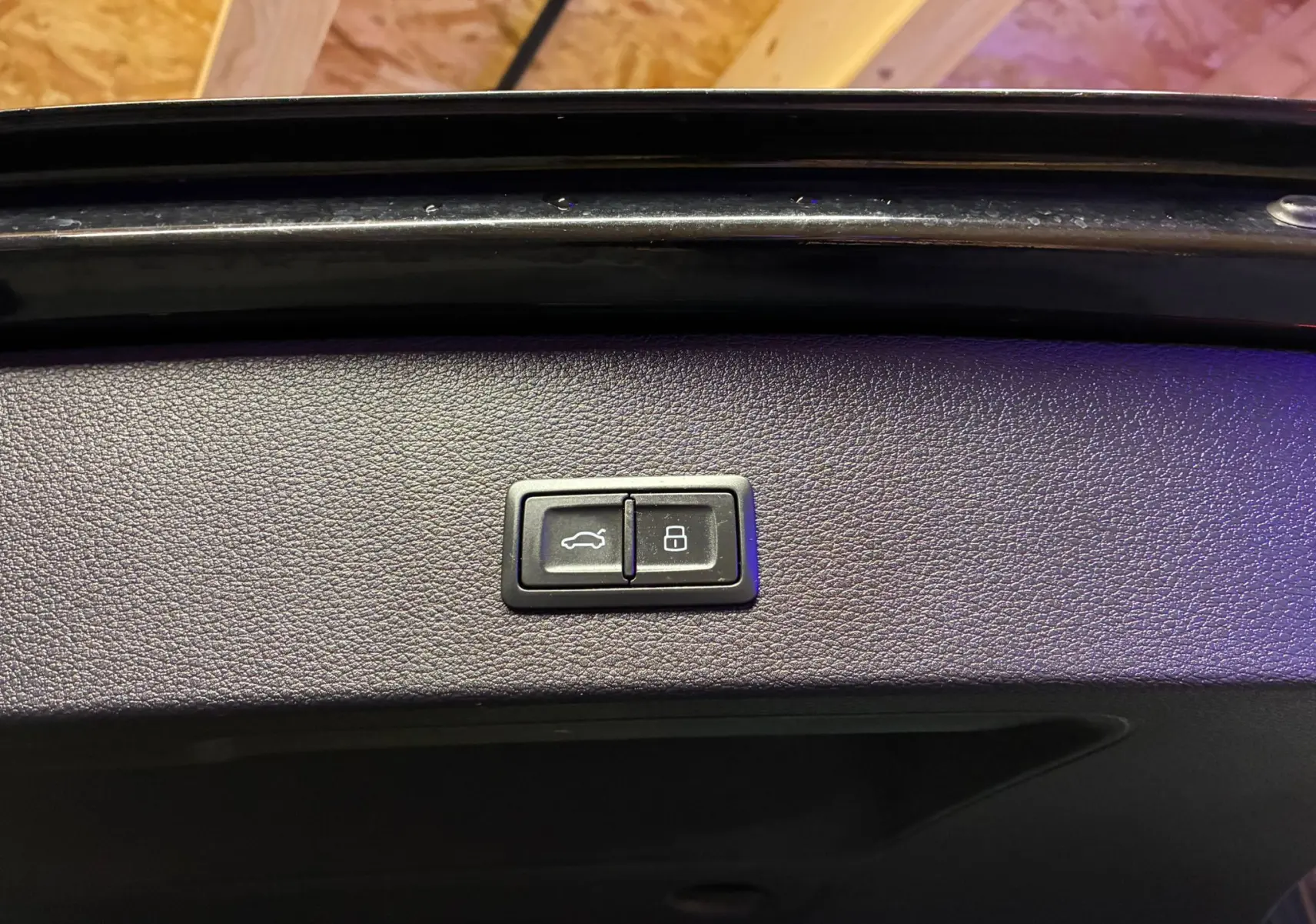 Boutons d'ouverture et de verrouillage du coffre sur la garniture intérieure noire d'un Audi Q2 35 TFSI S-Line 2023.