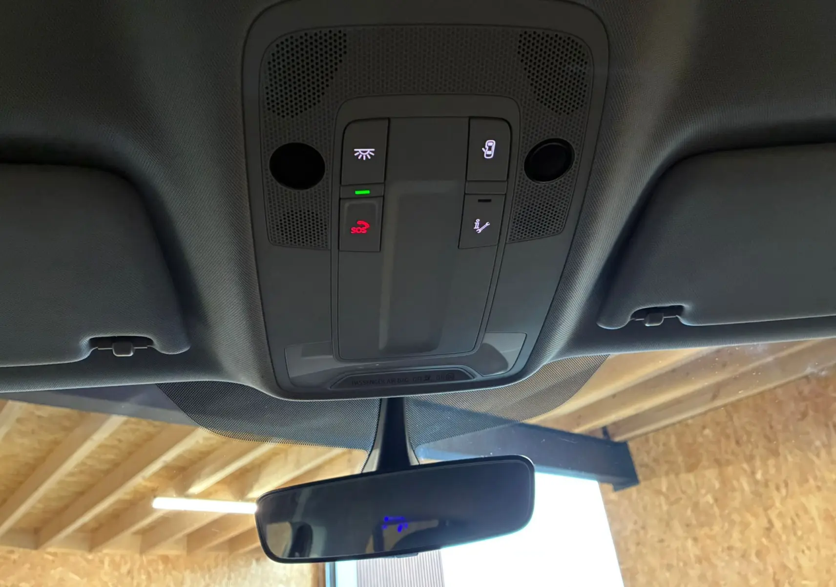 Vue intérieure du plafonnier noir de l'Audi Q2 35 TFSI 2023 avec commandes d'éclairage et bouton SOS éclairé en rouge.