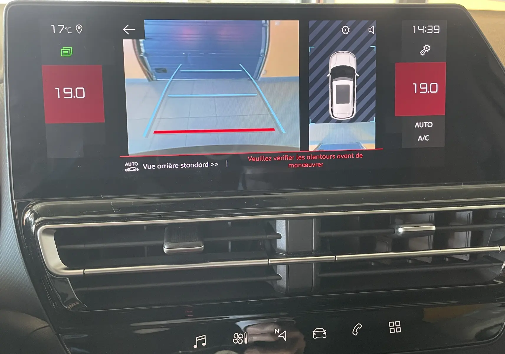 Écran central du tableau de bord du Citroën C5 Aircross hybride 2025 montrant la caméra de recul et la climatisation automatique.