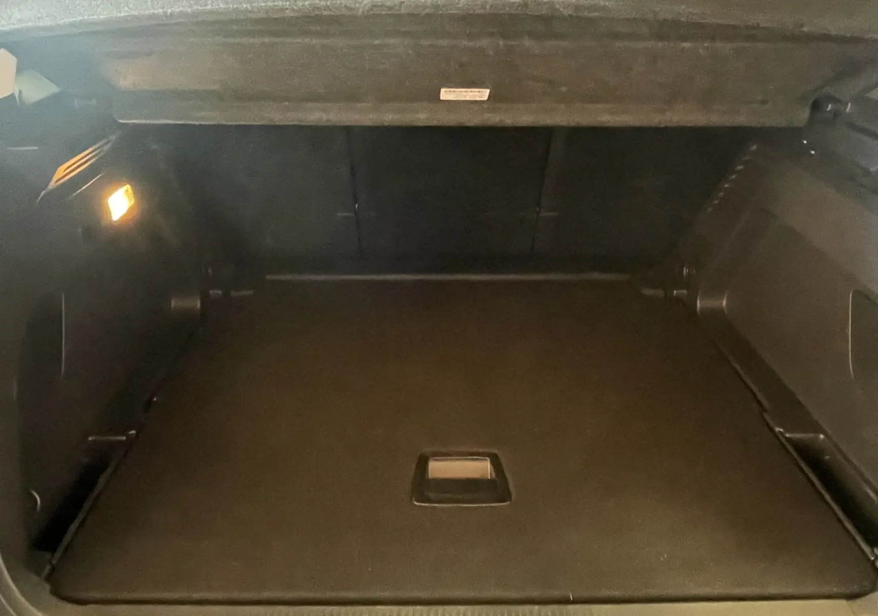 Coffre ouvert du Citroën C5 Aircross hybride gris platinium, vue intérieure montrant l'espace de chargement vide et éclairage latéral.