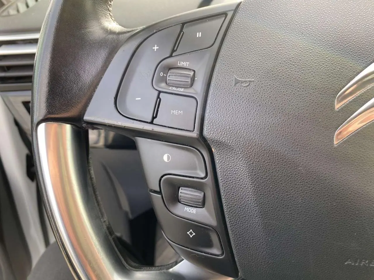 Gros plan sur le volant cuir noir de la Citroën Grand C4 Picasso 2015 avec commandes intégrées au volant.