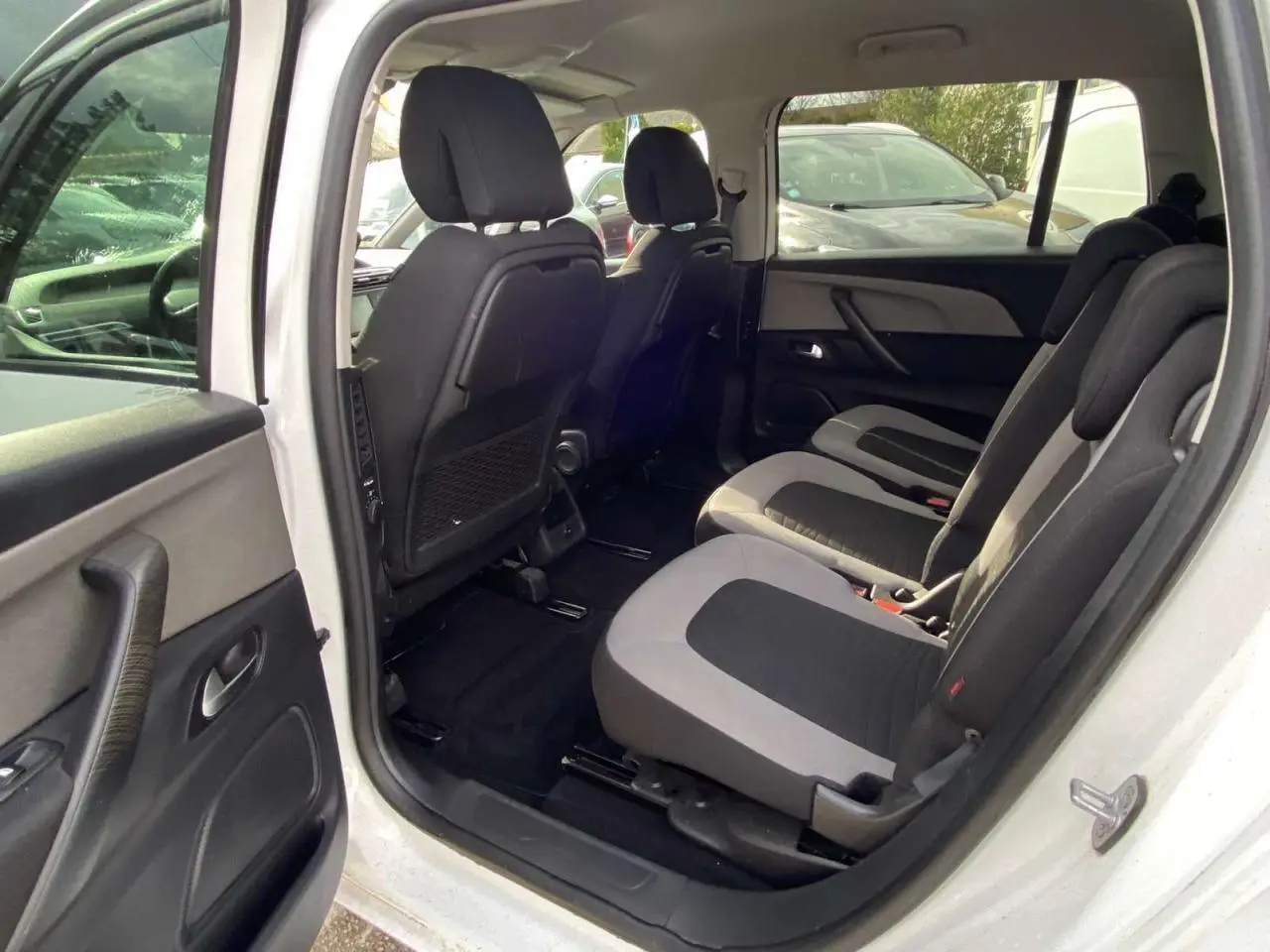 Vue intérieure côté droit sur les sièges arrière gris et noirs du Citroën Grand C4 Picasso blanc 7 places.