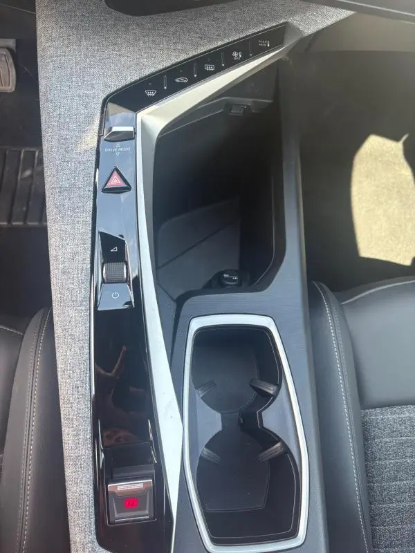 Vue plongeante sur la console centrale du Peugeot 3008 Hybrid 136 e-DCS6 Allure 2025, avec finitions gris clair et commandes tactiles.