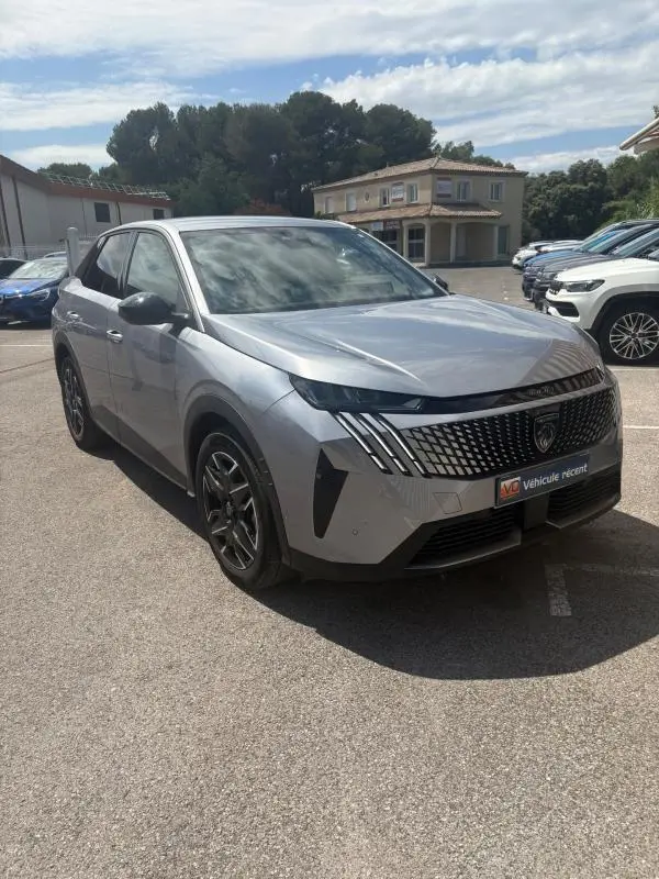 Peugeot 3008 Hybrid gris clair vue 3/4 avant droit, avec calandre distinctive et phares LED verticaux.
