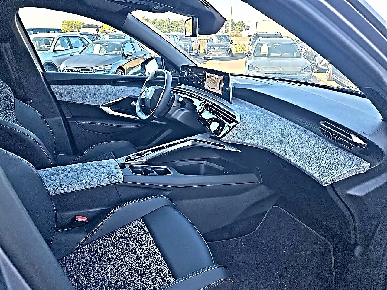 Vue intérieure côté conducteur du Peugeot 5008 Hybrid 145 allure e-dcs6 2025, tissus gris et tableau de bord moderne.