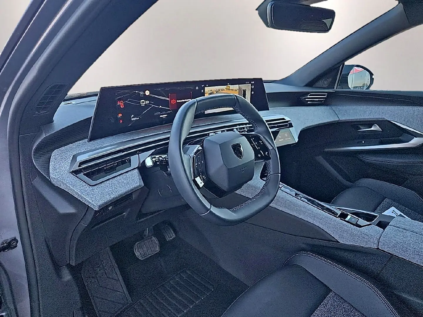 Intérieur avant du Peugeot 5008 Hybrid 145 allure e-dcs6 2025, volant cuir et tableau de bord numérique large.