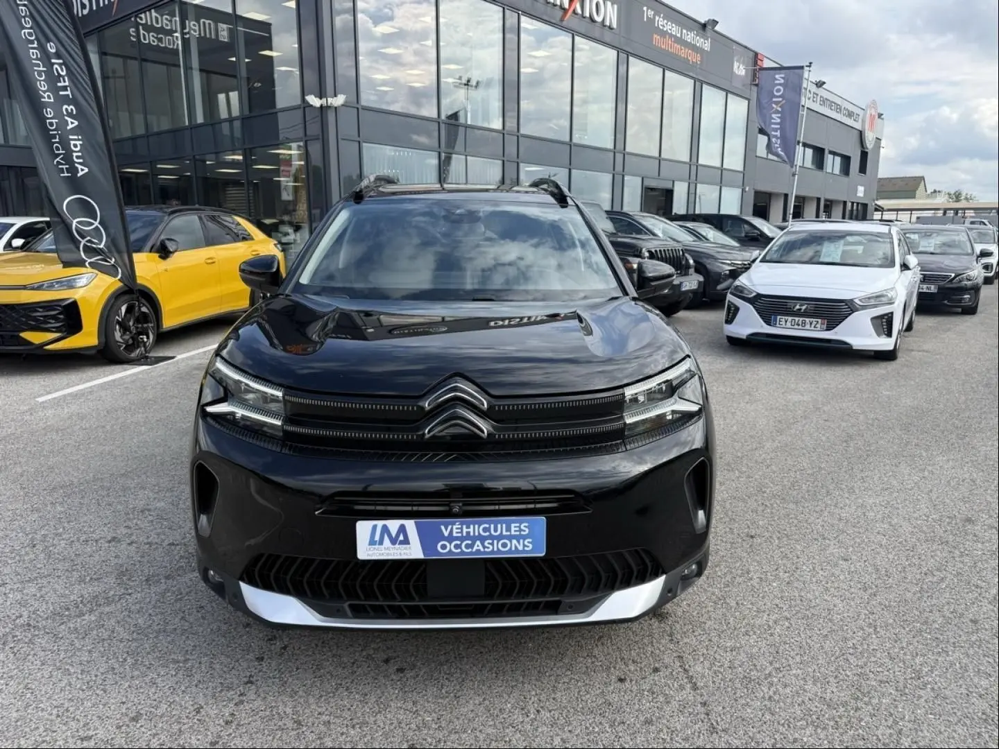 Citroën C5 Aircross noir métal vue de face, calandre distinctive avec logo double chevron et plaque "Véhicules Occasions".
