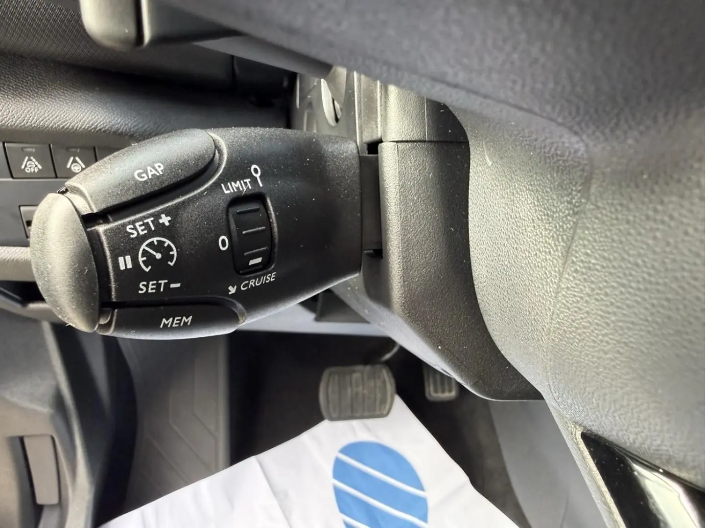 Gros plan sur la commande de régulateur de vitesse du Citroën C5 Aircross 2024 noir métal, côté gauche du volant.