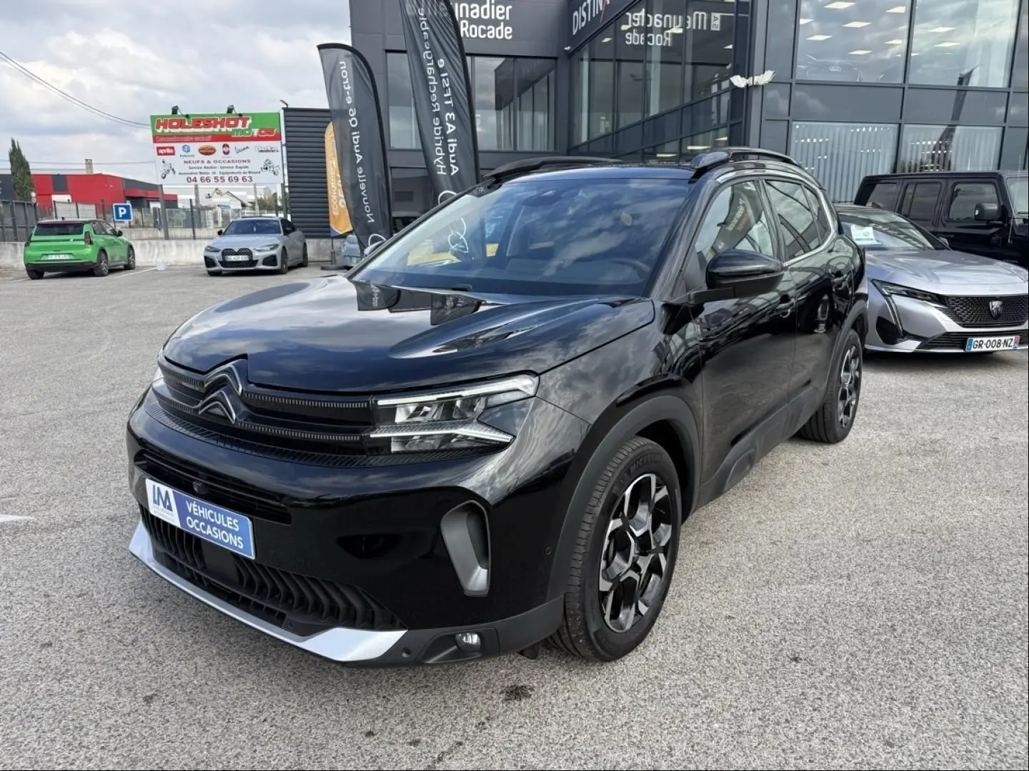 Citroën C5 Aircross 1.2 Hybride 145 cv noir métal, vue 3/4 avant droit avec jantes spécifiques et calandre distinctive.