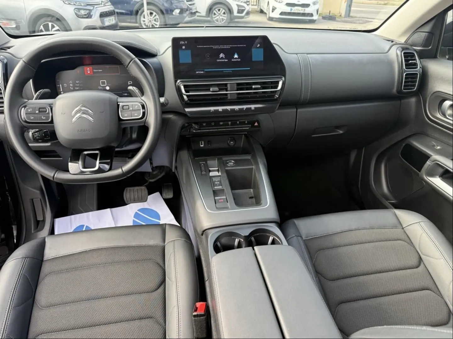 Vue intérieure avant du Citroën C5 Aircross 2024 noir métal, avec tableau de bord numérique et console centrale moderne.