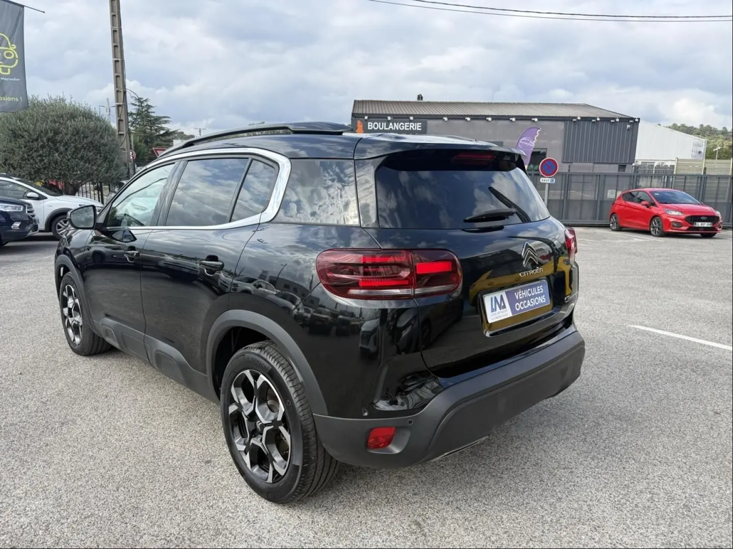 Vue 3/4 arrière droite du Citroën C5 Aircross 2024 noir métal avec jantes noires et vitres teintées.