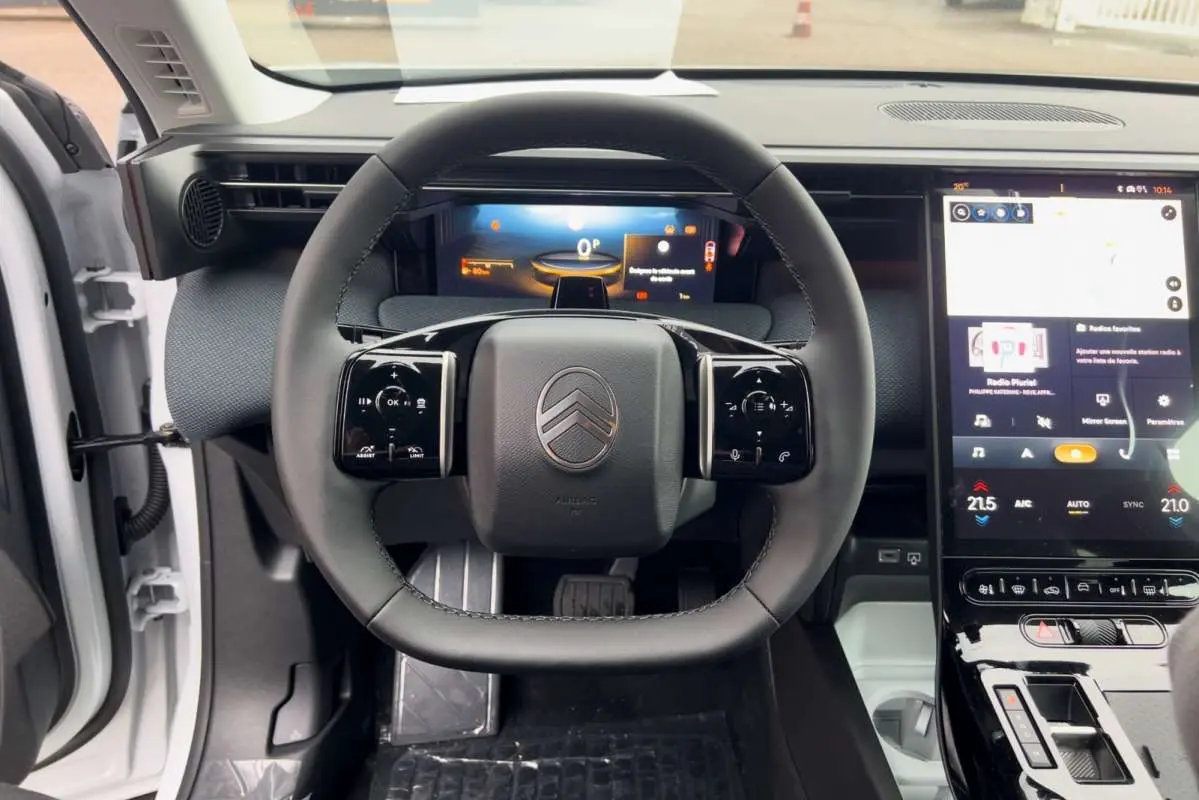 Vue centrée sur le volant cuir multifonctions du Citroën C5 Aircross Hybrid 2026 avec tableau de bord digital et écran tactile.