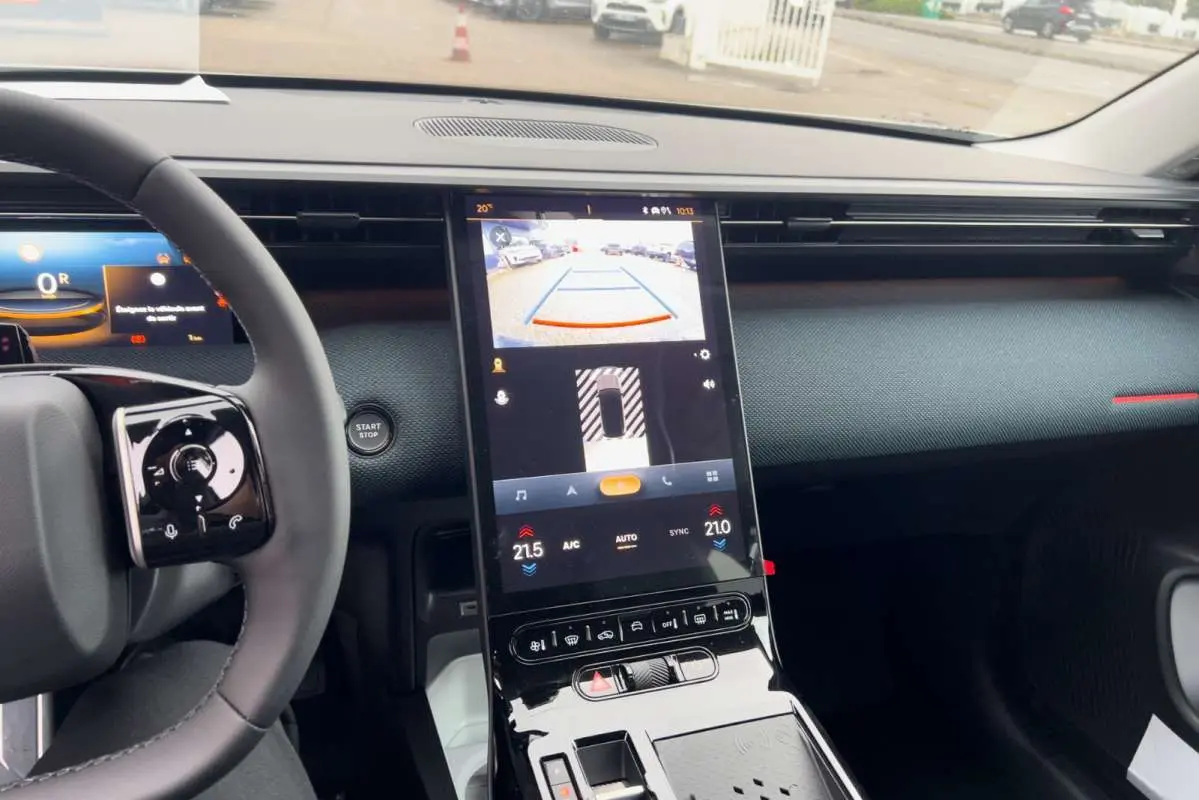 Vue intérieure centrée sur la console centrale tactile verticale du Citroën C5 Aircross Hybrid 2026 avec volant partiel.