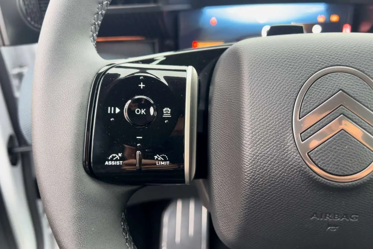 Gros plan sur les commandes multifonctions à gauche du volant cuir du Citroën C5 Aircross Hybrid 2026.