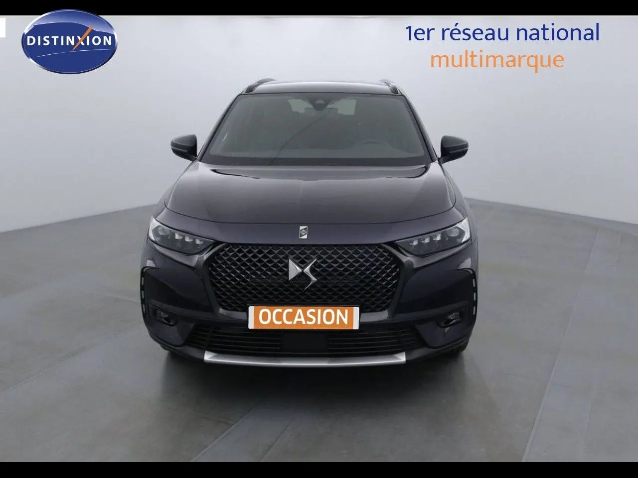 Vue de face d'un DS7 Crossback bleu encre métal avec calandre distinctive et plaque "OCCASION" visible.
