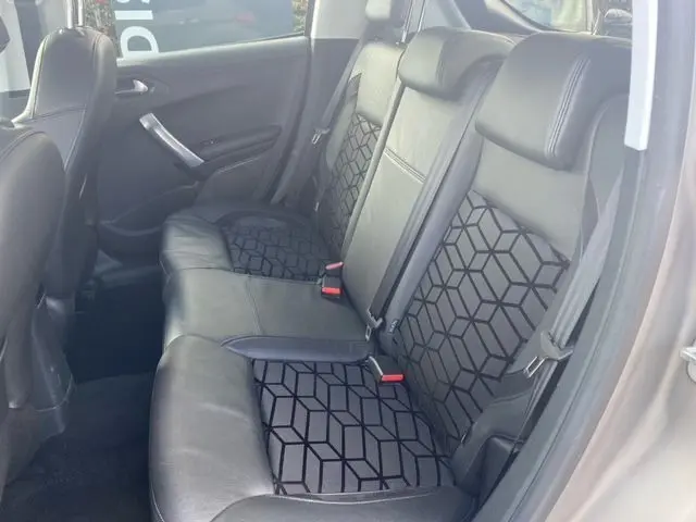 Vue intérieure de la banquette arrière en cuir noir avec motifs géométriques d'une Peugeot 208 gris mat de 2015.