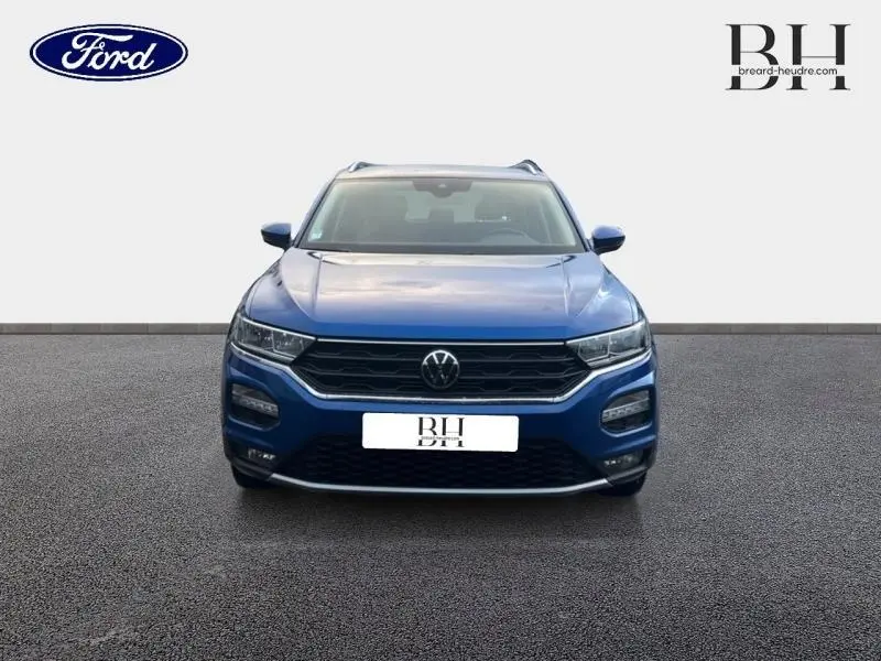 Vue avant d'un Volkswagen T-Roc 1.0 TSI bleu Ravenna métallisé avec calandre noire et feux LED intégrés.