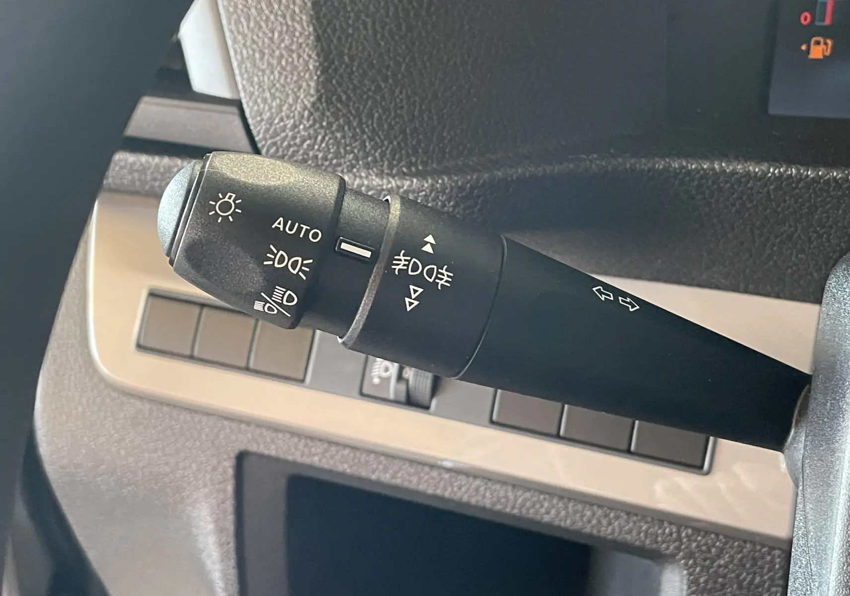 Gros plan sur la manette de commande des feux et clignotants du Citroën Jumpy Cabine Approfondie gris Artense, intérieur noir.