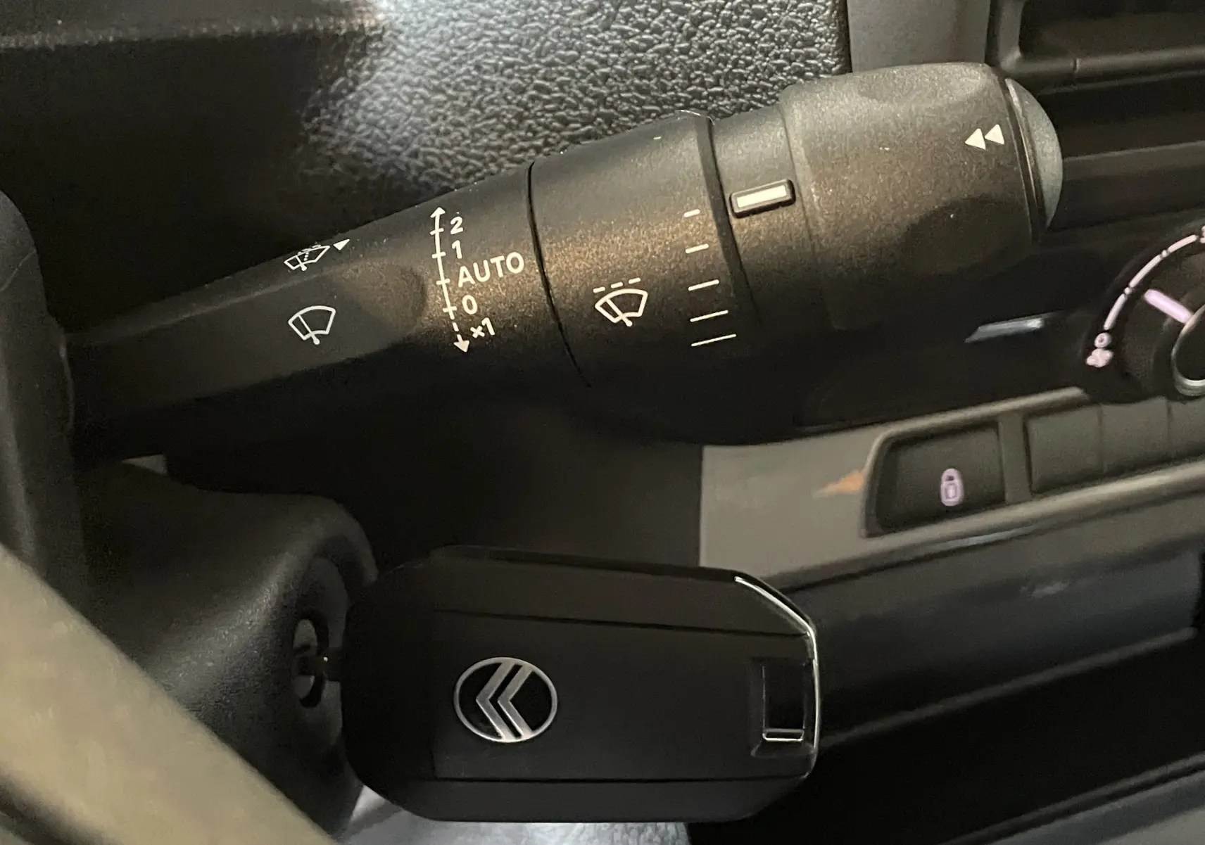 Gros plan sur la commande d’essuie-glace et la clé de contact dans l’habitacle du Citroën Jumpy Cabine Approfondie gris Artense.