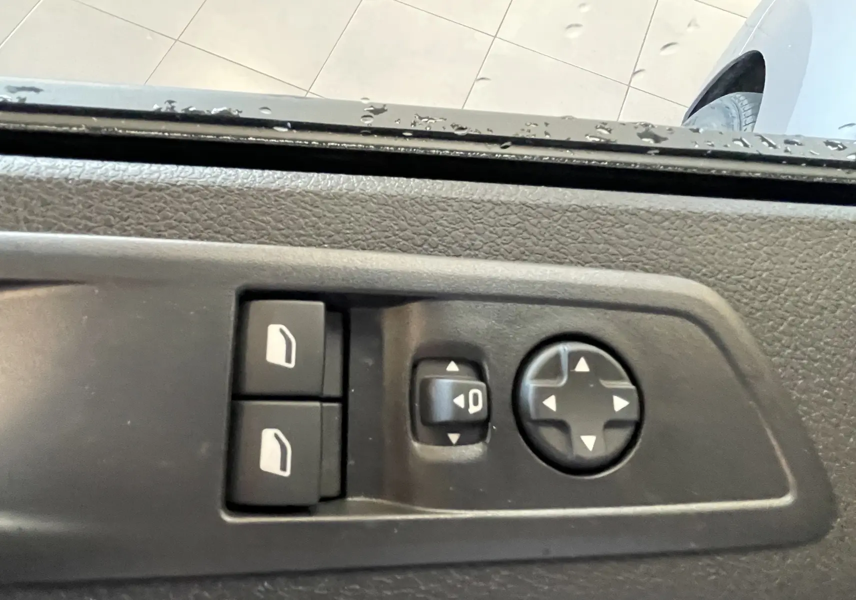 Gros plan sur les commandes de réglage des rétroviseurs et vitres côté conducteur du Citroën Jumpy gris Artense.
