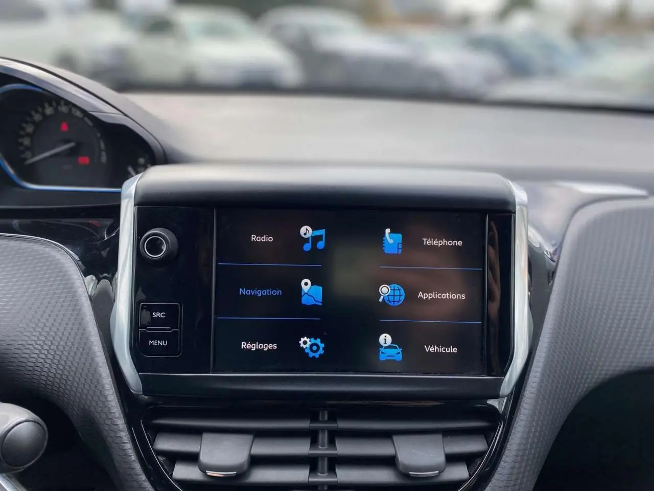 Vue rapprochée du tableau de bord du Peugeot 2008 gris platinium, avec écran tactile affichant les options de navigation et téléphone.