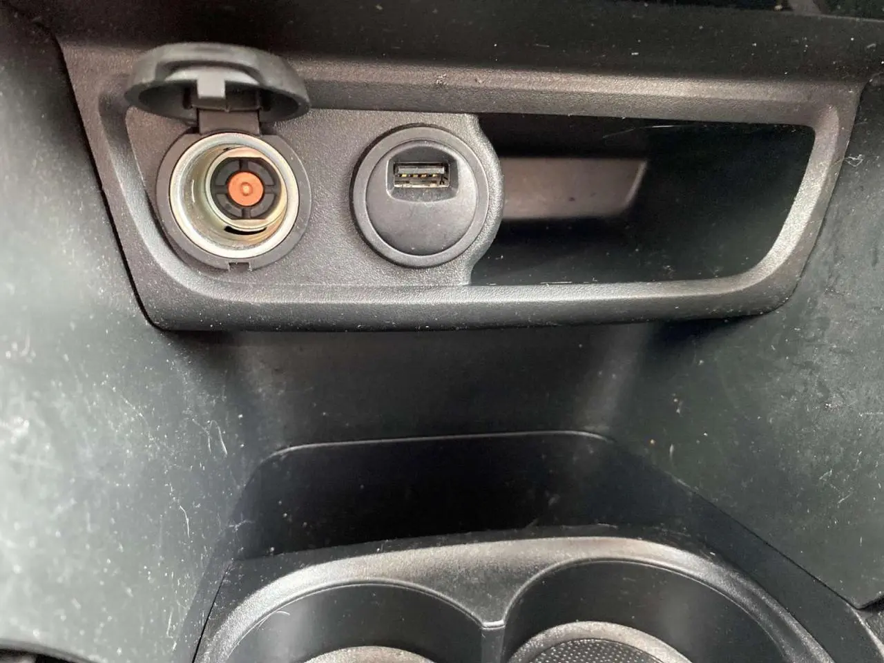 Détail de la prise allume-cigare et port USB dans la console centrale d’un Peugeot 2008 gris platinium.