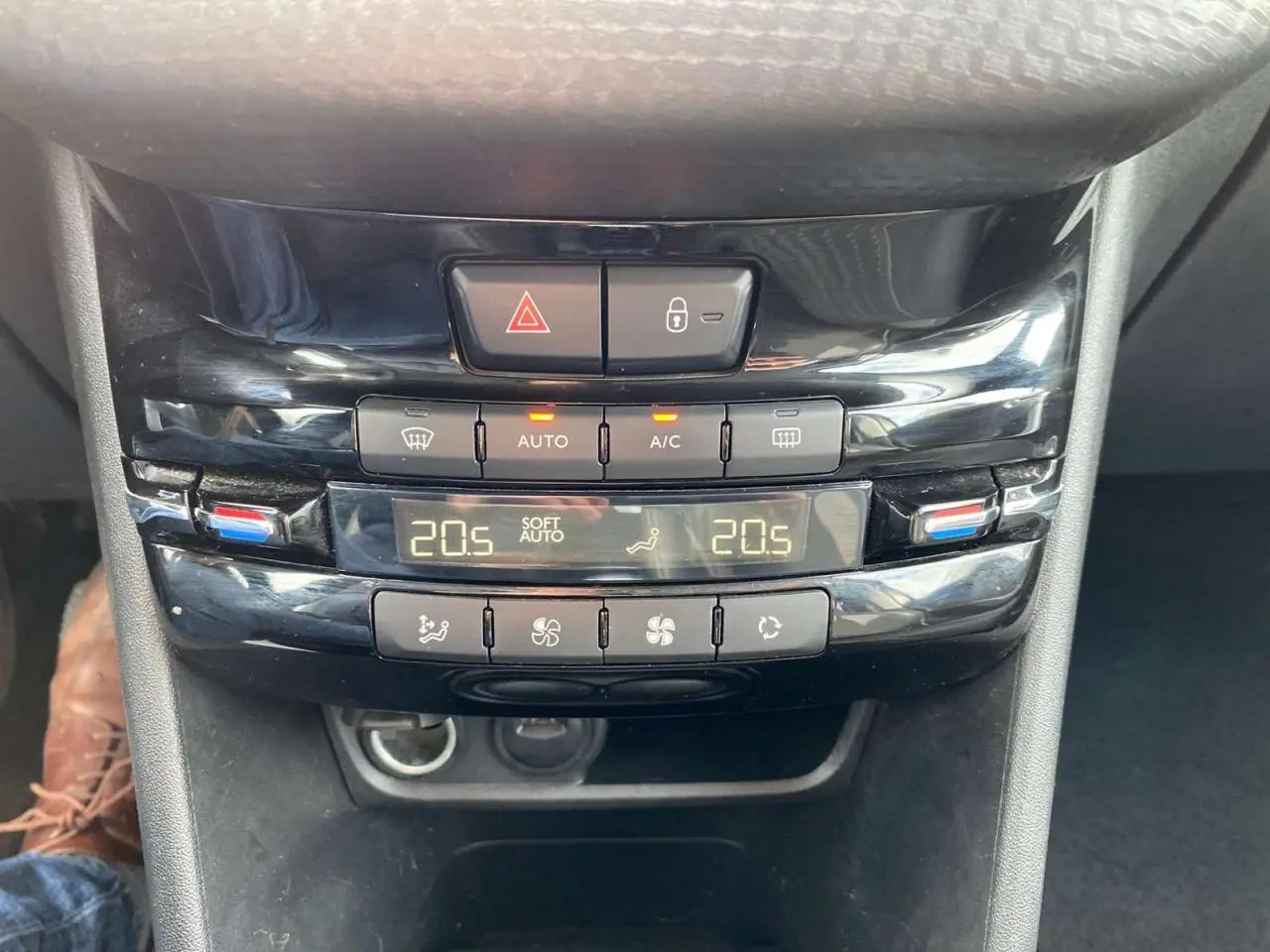 Gros plan sur la console centrale noire brillante du Peugeot 2008 avec commandes climatisation automatique bizone affichant 20,5°C.