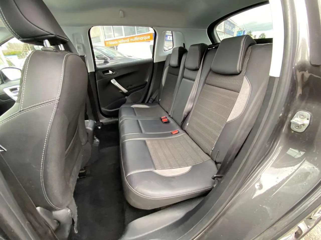 Vue intérieure côté droit sur la banquette arrière en cuir noir et tissu gris du Peugeot 2008 gris platinium de 2019.