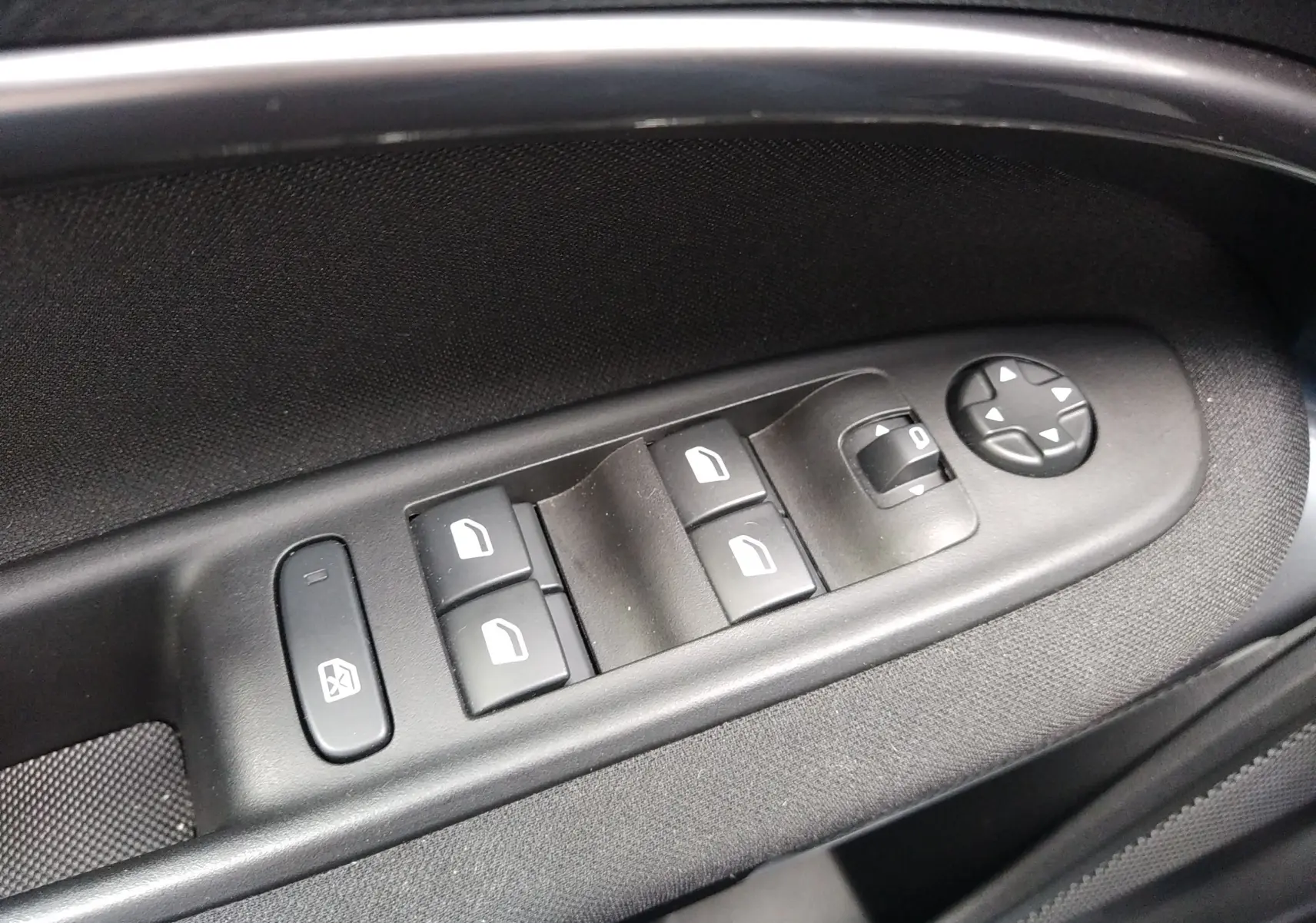 Commande des vitres électriques et réglage des rétroviseurs sur la porte côté conducteur d'une FIAT 600 noire.